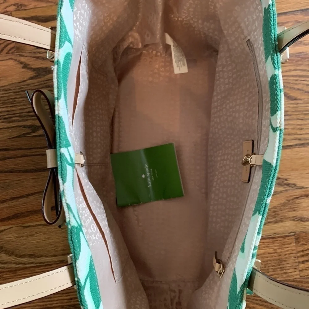 Kate Spade cream colored cloth tote with green leaf pattern.